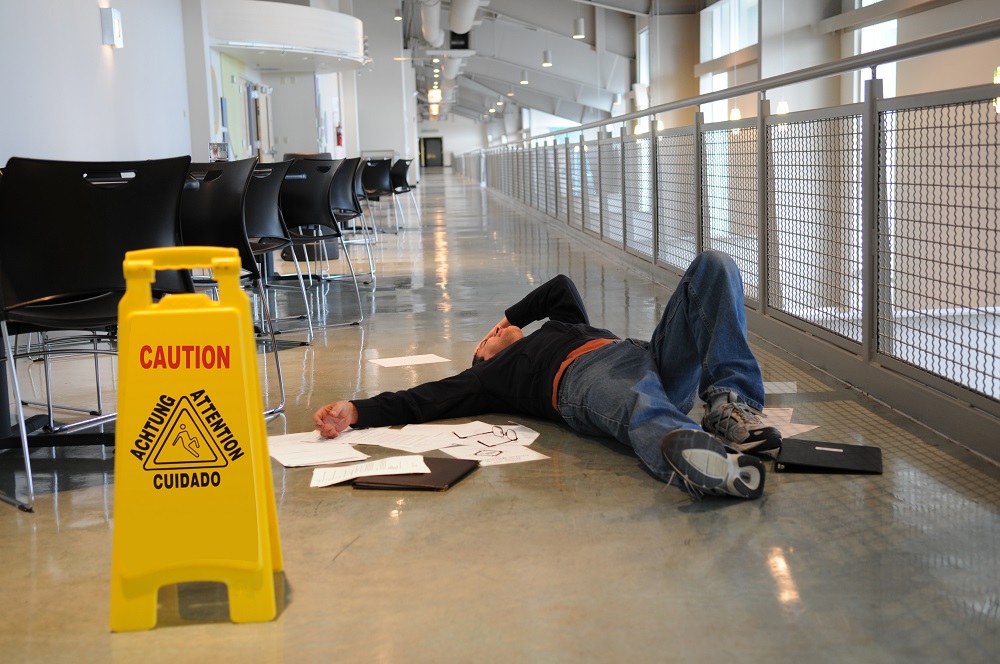 Businessman slipping on wet floor inside office building.