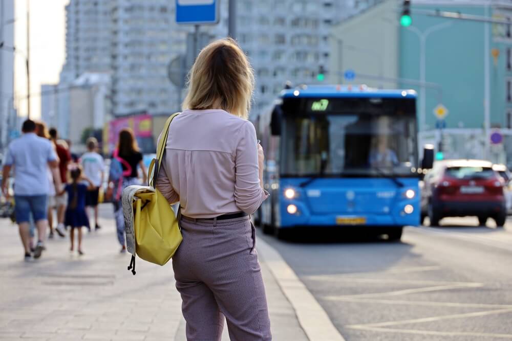 Lady commuter waiting for her bus to arrive.