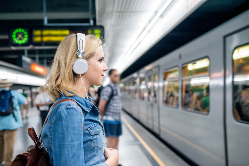 Girl on headset waiting for the train.