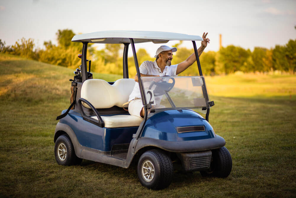 Senior man riding the golf cart.