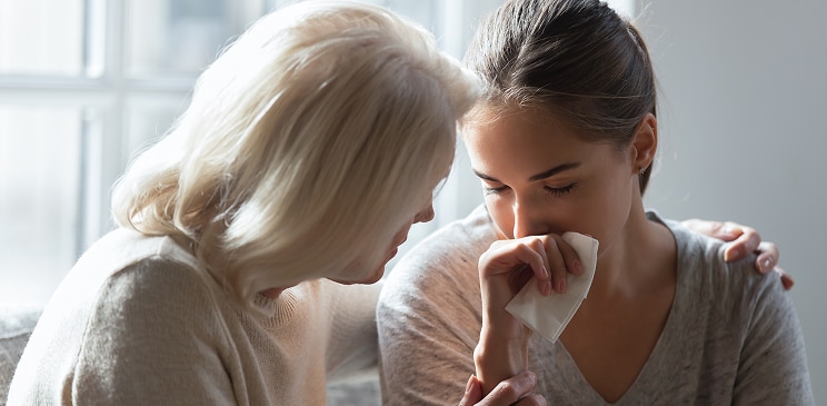Image of a woman comforting another woman